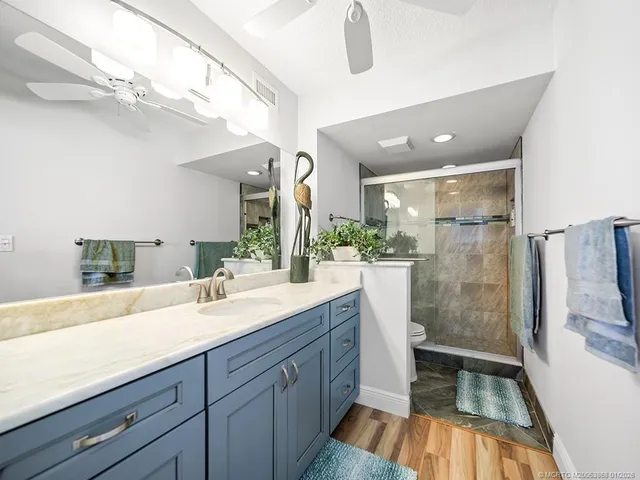 a spacious bathroom with a double vanity sink a large mirror and shower