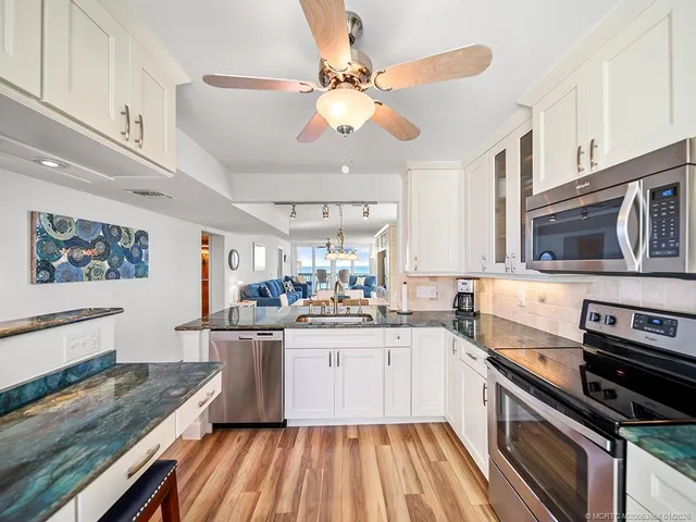 a kitchen with stainless steel appliances granite countertop a sink and stove top oven