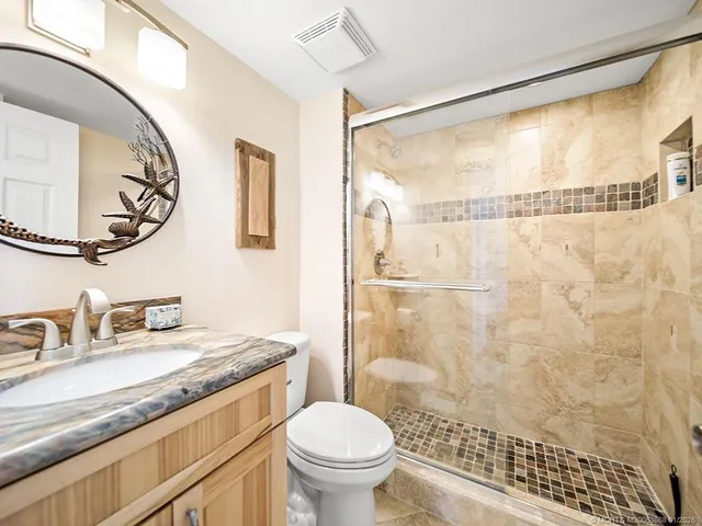 a bathroom with a granite countertop sink toilet and shower