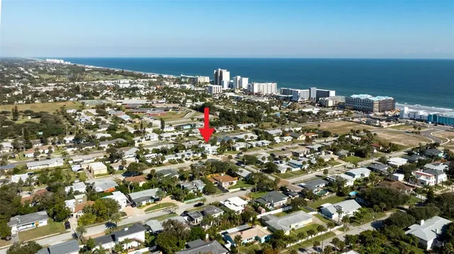 a view of a house with a yard and coconut trees