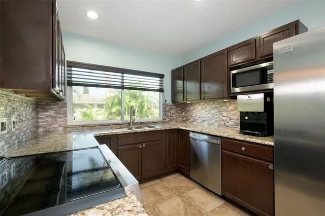 an empty room with kitchen and windows