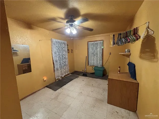 a view of a livingroom with a chandelier furniture and a ceiling fan