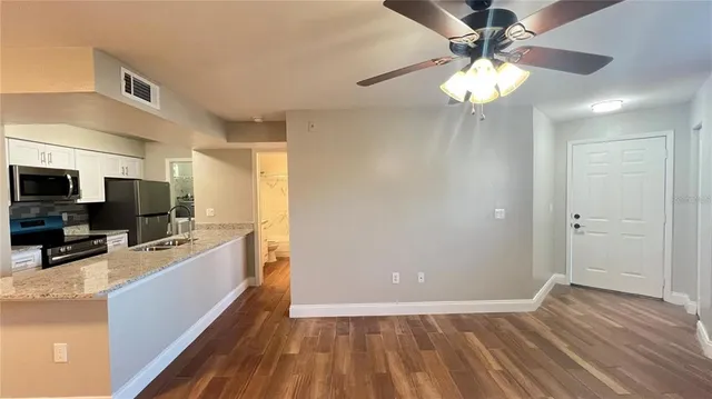 a view of a kitchen with stainless steel appliances granite countertop a refrigerator and a sink