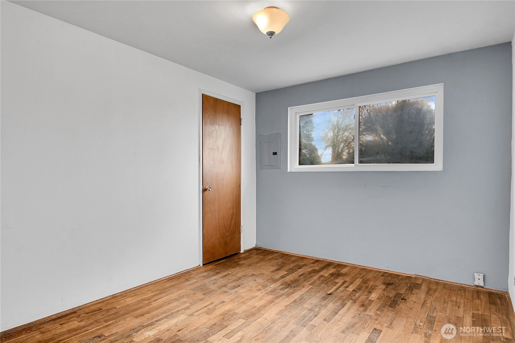 15771 119th Place Southeast Renton, WA 98058 - Photo 12 of 20 a view of an empty room with wooden floor and a window