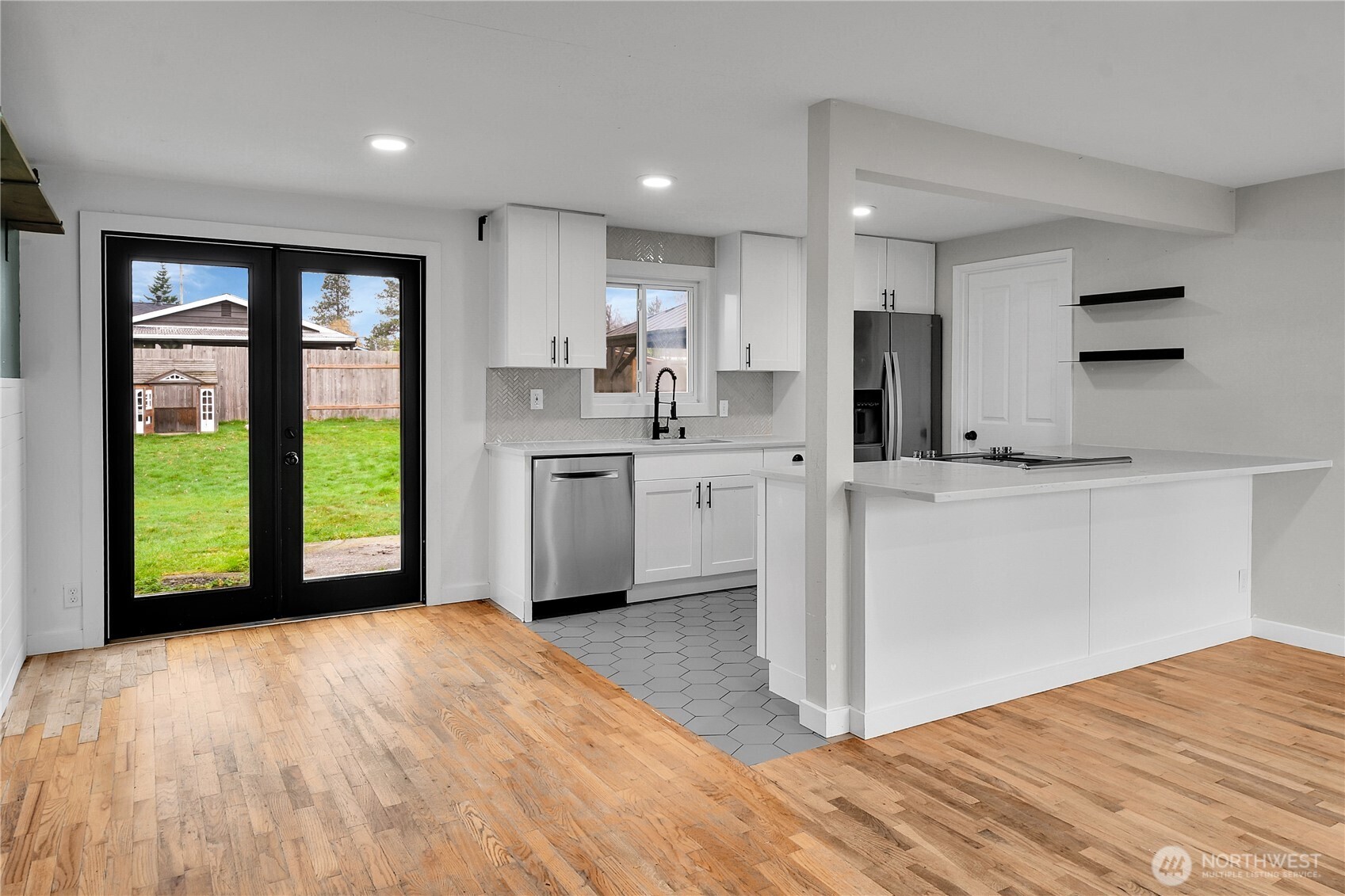 15771 119th Place Southeast Renton, WA 98058 - Photo 4 of 20 a view of a kitchen with a sink a stove top oven and cabinets