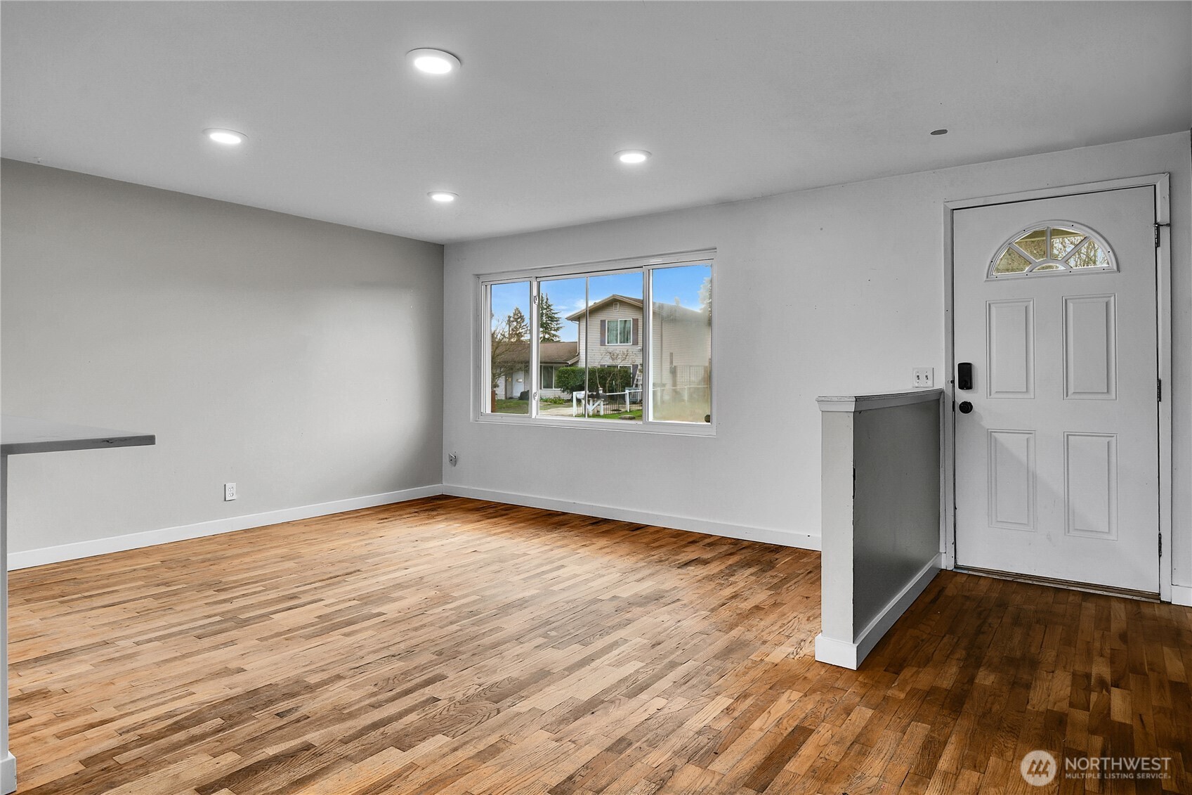 15771 119th Place Southeast Renton, WA 98058 - Photo 5 of 20 a view of an empty room with window and wooden floor