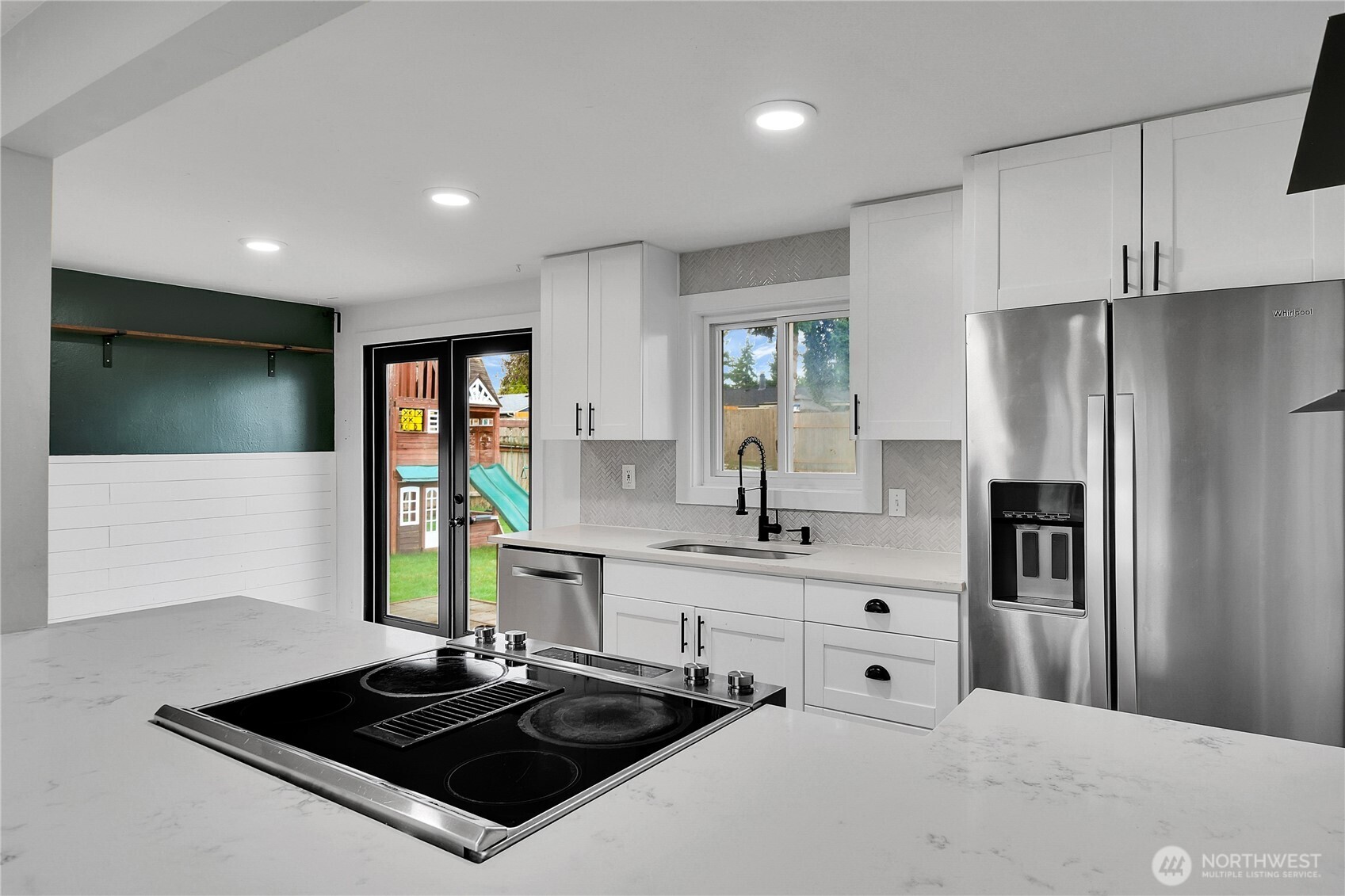 15771 119th Place Southeast Renton, WA 98058 - Photo 9 of 20 a kitchen with stainless steel appliances a sink a stove a refrigerator cabinets and a window