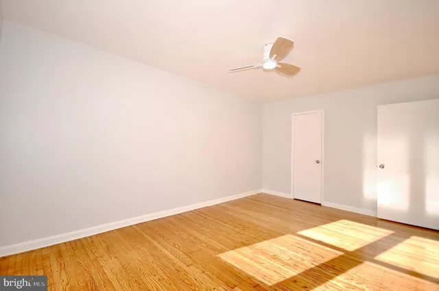 a view of a room with wooden floor and ceiling fan