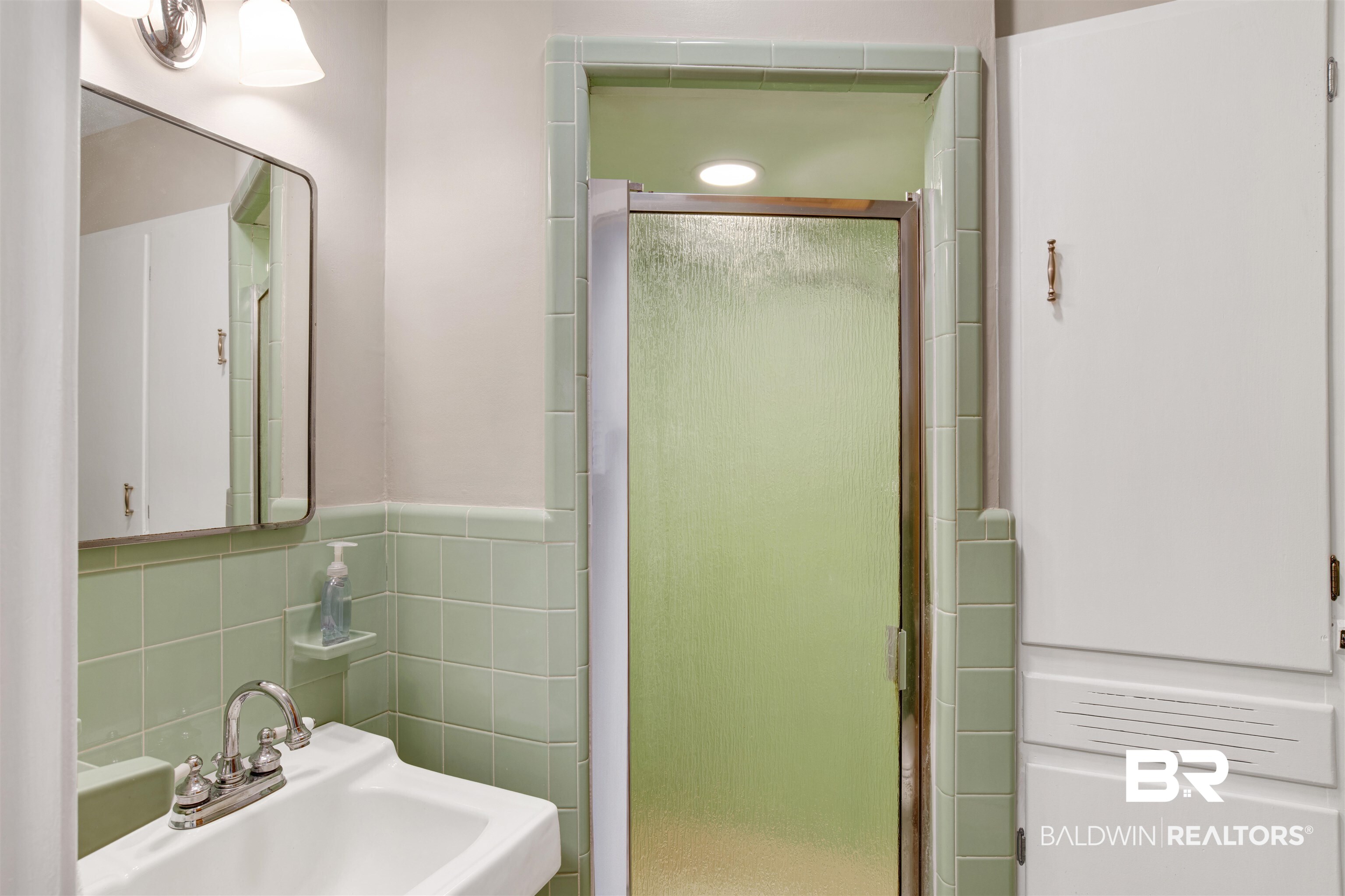 18347 Underwood Road Foley, AL 36535 - Photo 18 of 40 Bathroom featuring a sink, a stall shower, and tile walls
