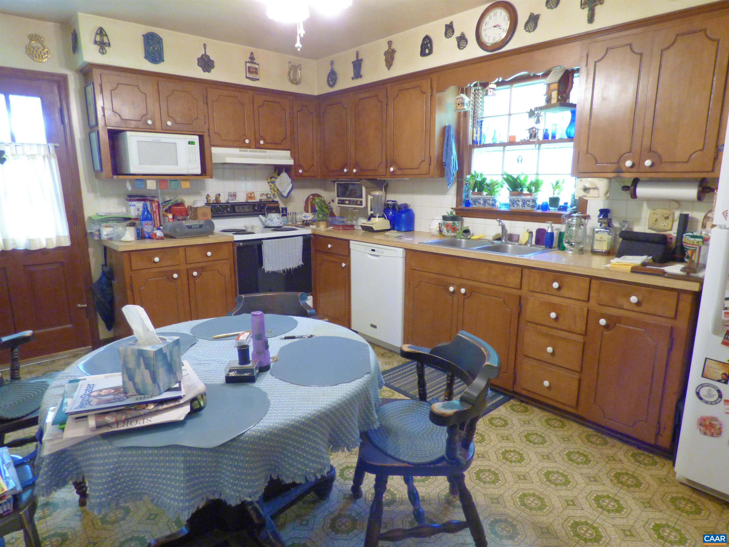 282 Kenmore Road Amherst, VA 24521 - Photo 9 of 33 a kitchen with stainless steel appliances granite countertop a sink dishwasher a dining table and chairs with wooden floor
