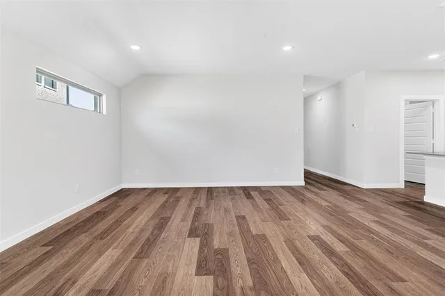 a view of an empty room with wooden floor