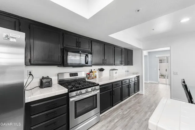 a kitchen with white cabinets and stainless steel appliances