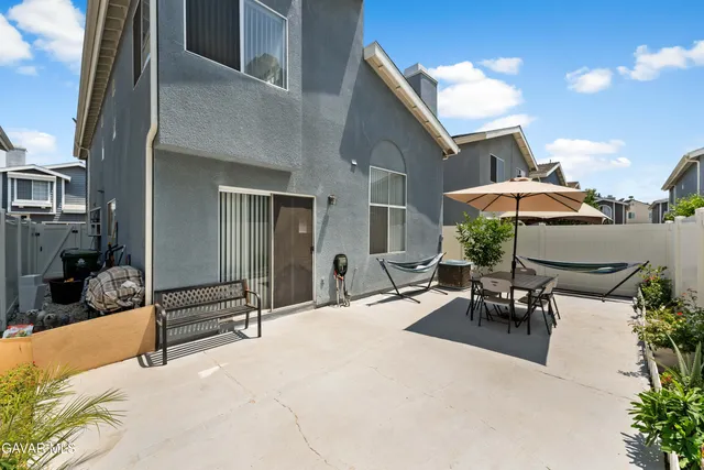 a view of a patio with a table and chairs under an umbrella