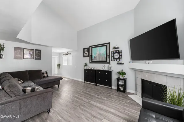 a living room with furniture a flat screen tv and a fireplace
