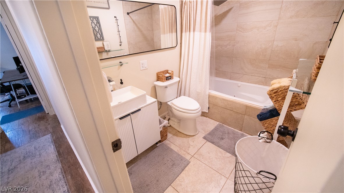 425 Blackridge Road Henderson, NV 89015 - Photo 16 of 31 Tiled walls and large ceramic floor tiles define this modern full bathroom.