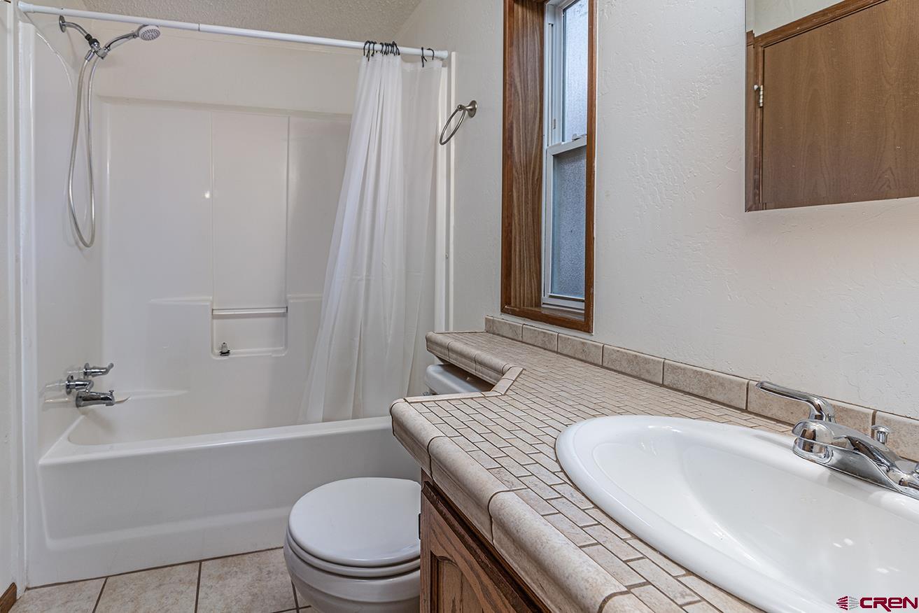 32 Hidden Lane Durango, CO 81303 - Photo 11 of 26 a bathroom with a granite countertop sink toilet a mirror and shower