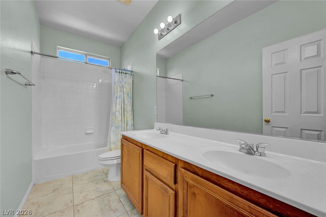 977 Sparkling Light Street Henderson, NV 89052 - Photo 54 of 75 This bathroom features a double vanity with ample counter space and a tiled floor.