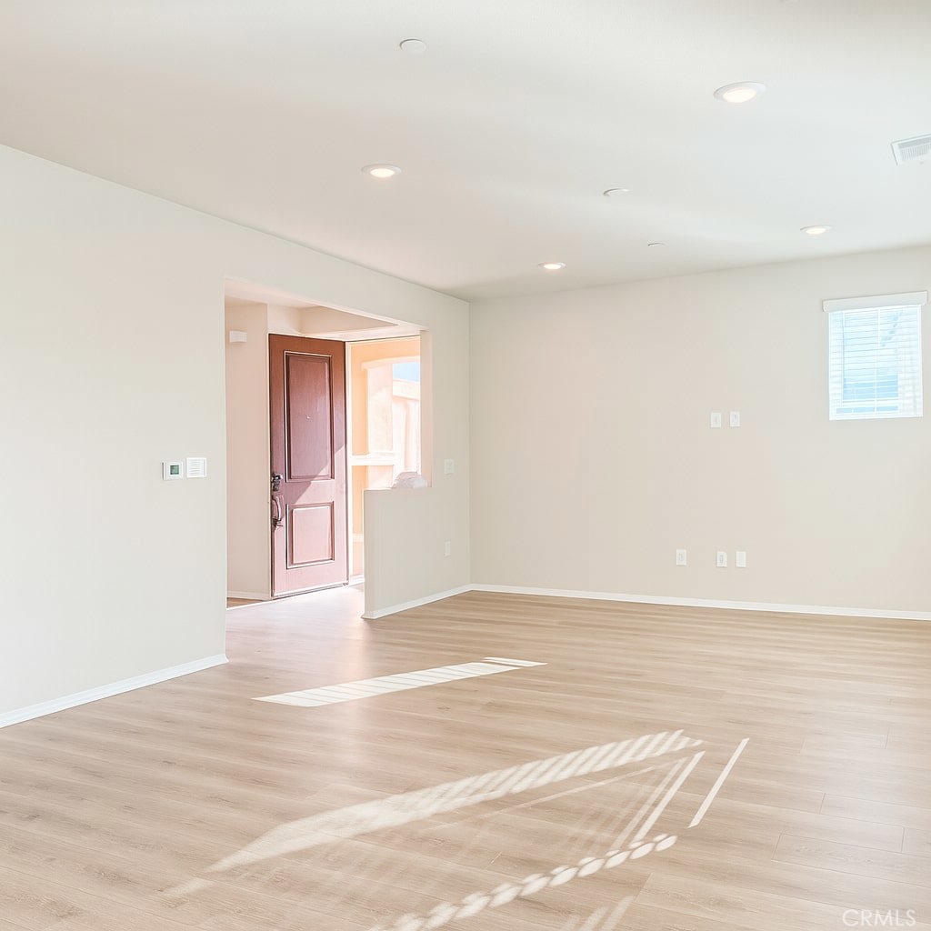1120 Tropic Court, Unit 306 Redlands, CA 92374 - Photo 4 of 18 a view of an empty room with wooden floor and a window