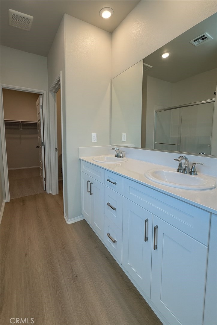 1120 Tropic Court, Unit 306 Redlands, CA 92374 - Photo 10 of 18 a spacious bathroom with a sink a mirror and a shower
