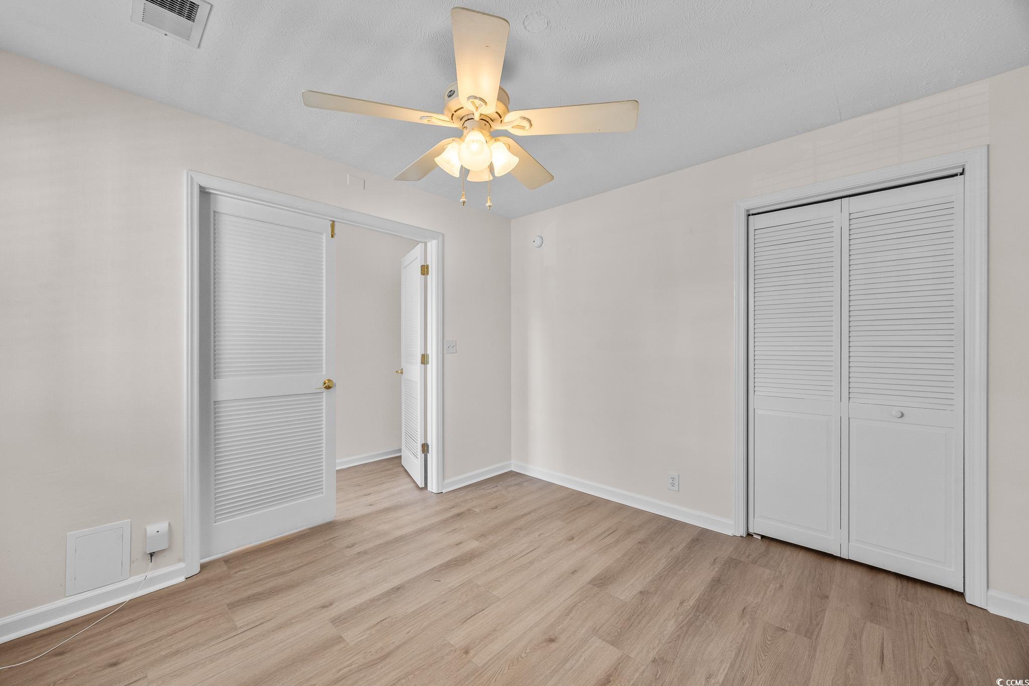 673 Tupelo Lane, Unit 19H Longs, SC 29568 - Photo 19 of 22 Unfurnished bedroom featuring light wood finished floors, ceiling fan, and a closet