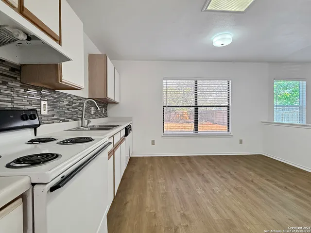 a kitchen with a sink stove top oven and cabinets