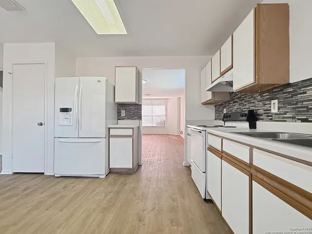 a kitchen with white cabinets and white appliances