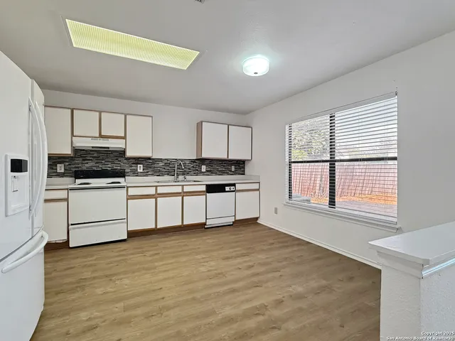 a kitchen with white cabinets and white appliances