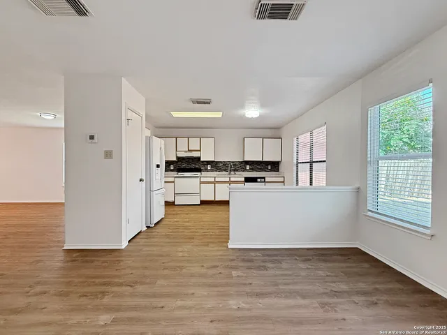 a view of kitchen with wooden floor and electronic appliances