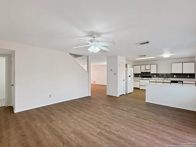 a view of kitchen with granite countertop cabinets and refrigerator