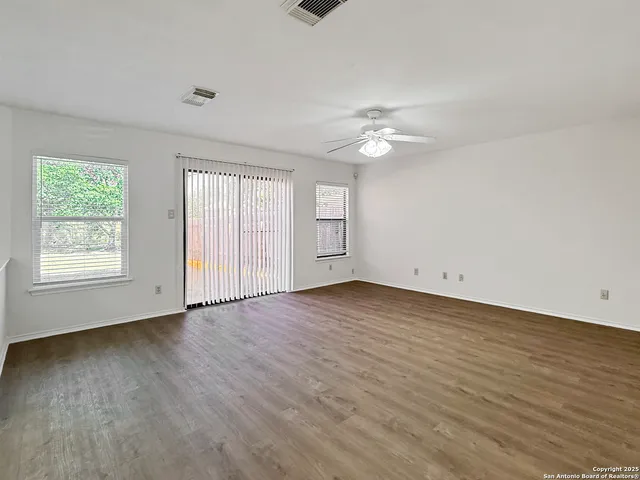 wooden floor in an empty room with a window