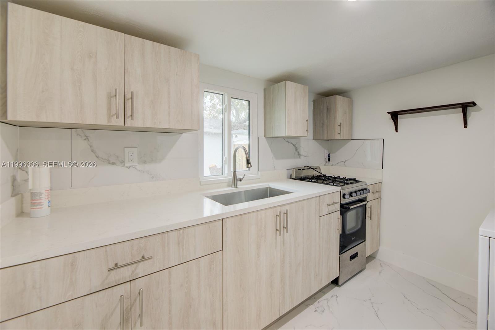 20201 Southwest 117th Court Miami, FL 33177 - Photo 13 of 18 a kitchen with stainless steel appliances granite countertop white cabinets and a sink