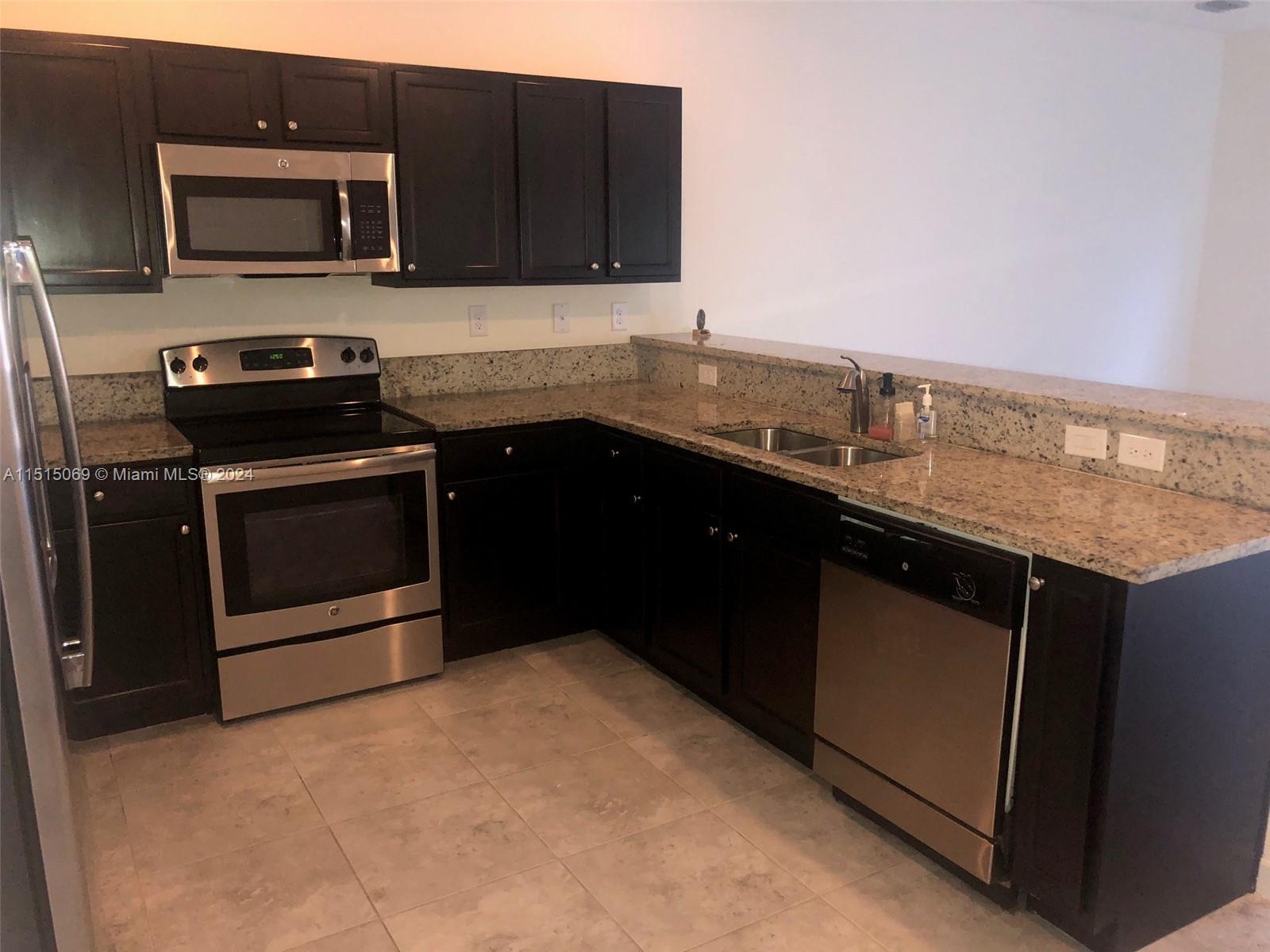 15053 Southwest 115th Terrace Miami, FL 33196 - Photo 15 of 29 a kitchen with stainless steel appliances granite countertop a stove a microwave and a sink