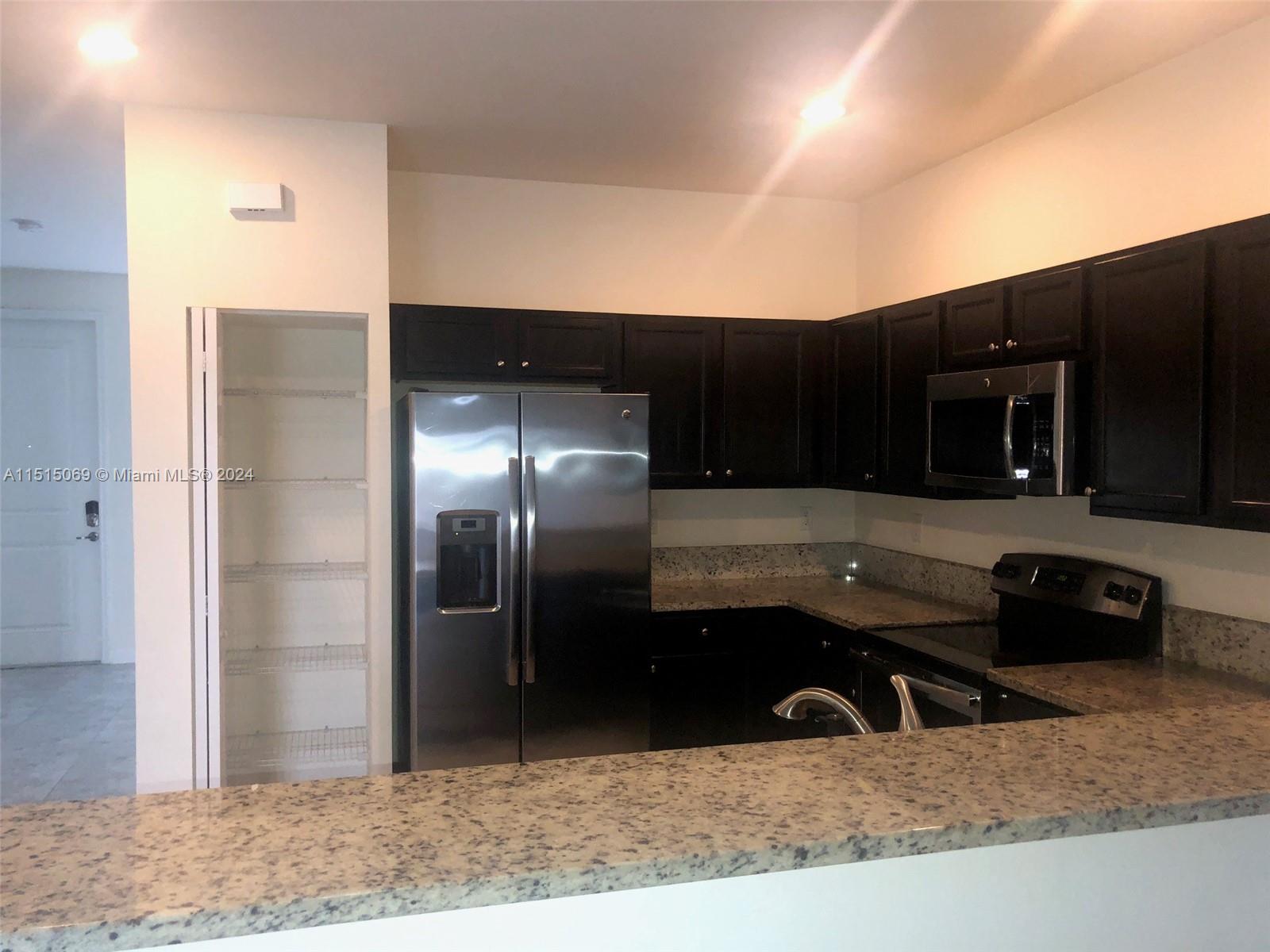15053 Southwest 115th Terrace Miami, FL 33196 - Photo 18 of 29 a kitchen with stainless steel appliances kitchen island granite countertop a refrigerator and a sink