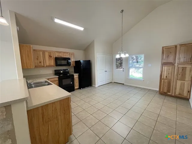 a kitchen that has a lot of cabinets in it and appliances