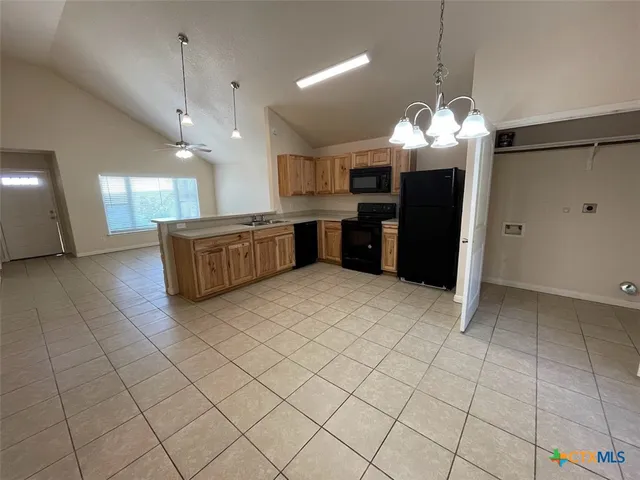 a large kitchen with a large counter top stainless steel appliances and cabinets