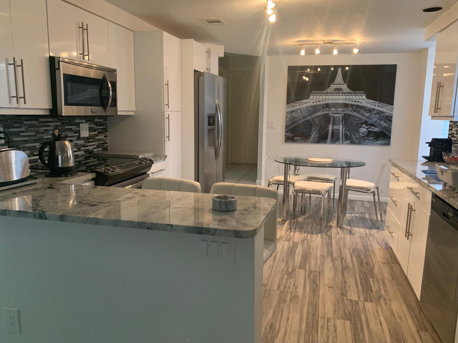 7770 La Mirada Drive Boca Raton, FL 33433 - Photo 37 of 55 a kitchen with stainless steel appliances granite countertop a stove a sink and a microwave