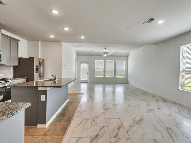 a view of a kitchen with kitchen island granite countertop lots of counter top space