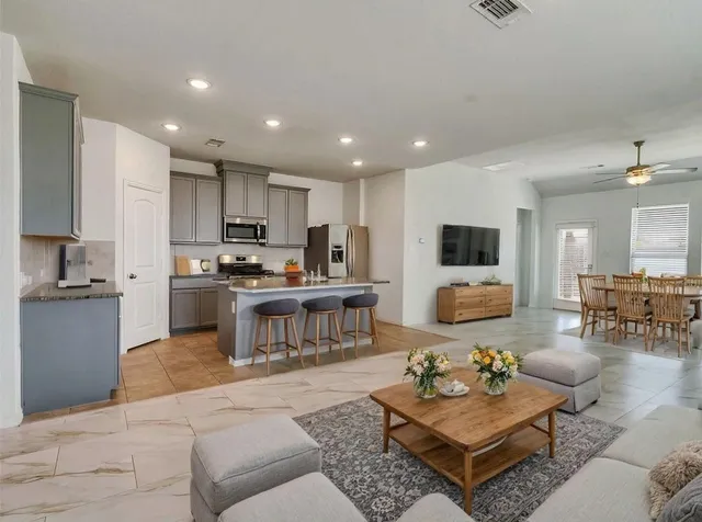 a living room filled with furniture and kitchen view