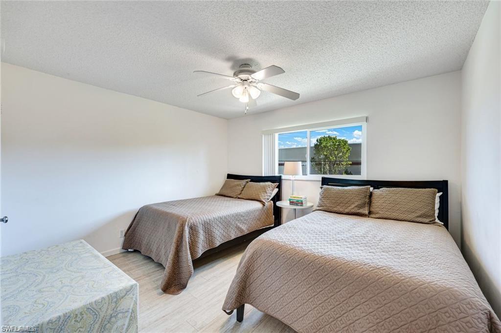2000 Alamanda Drive, Unit 206 Naples, FL 34102 - Photo 17 of 31 a bedroom with two beds and a chandelier