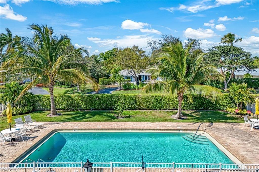 2000 Alamanda Drive, Unit 206 Naples, FL 34102 - Photo 22 of 31 a view of backyard with swimming pool and green space