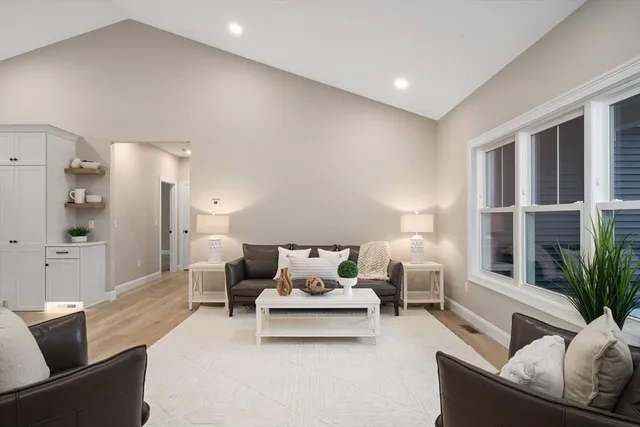 a living room with furniture kitchen view and a chandelier
