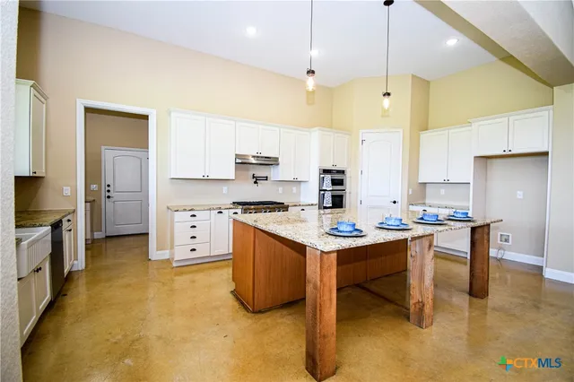 a kitchen that has a lot of cabinets in it and appliances