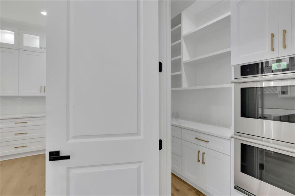 3893 Indian Shoals Road Southeast Bethlehem, GA 30620 - Photo 14 of 63 a kitchen with white cabinets and white appliances