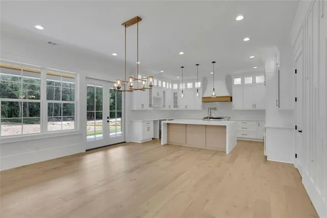 a view of a kitchen with kitchen island a sink stainless steel appliances and cabinets