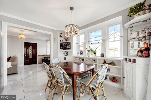 a dining room with furniture a chandelier and kitchen view