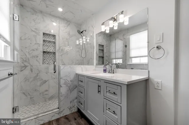 a bathroom with a double vanity sink mirror and shower