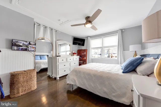 a bedroom with a large bed and wooden floor
