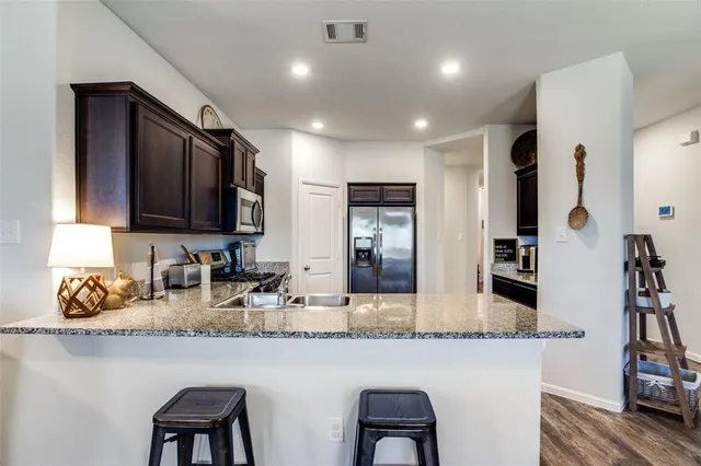 a kitchen with stainless steel appliances granite countertop a stove microwave and sink