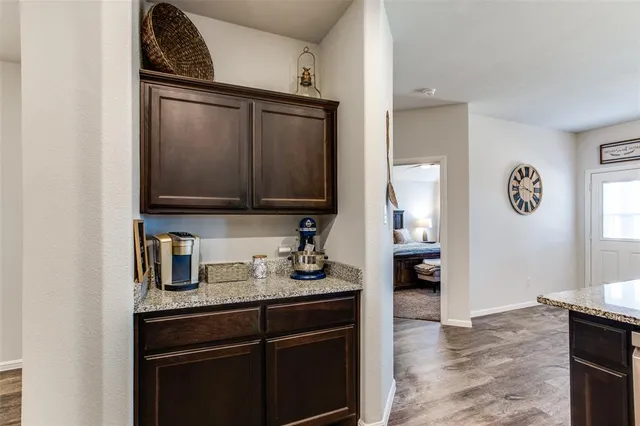 a spacious bedroom with a bed a dresser and a chandelier