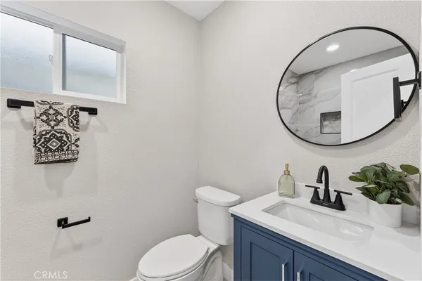 a bathroom with a sink mirror and toilet